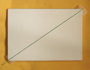 Une première diagonale (marquée ici par un fil de couleur) sur un support quelconque.